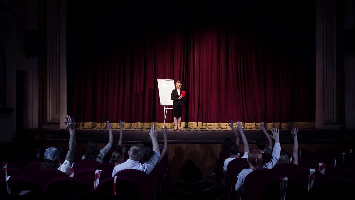 Talking to students. Female speaker giving presentation in hall at workshop. Business centre. Rear view of participants in audience. Conference event, training. Education, meeting, business concept.